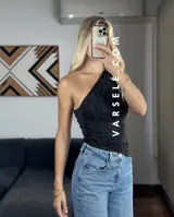 Top asimétrico negro con un solo tirante y detalle de strass plateados.