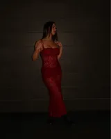 Vestido largo de encaje rojo con breteles finos y corte ajustado.