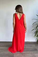 Vestido largo rojo vibrante, de corte holgado y sin mangas, con escote en V pronunciado y bolsillos laterales.
