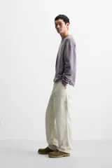 Jersey de hombre color lila, tejido en hilatura de algodón con textura. Tiene cuello redondo, manga larga y acabados en rib con detalle de vuelta.