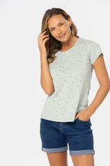 Remera color crema con estampado de hojas azules, de manga corta y cuello redondo.