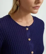 Cardigan cropped de punto color azul marino, con cuello redondo, punto texturizado y cierre frontal con botones contrastantes.