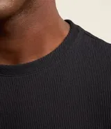 Remera de media malla color blanco, con cuello redondo y manga corta. Presenta textura vertical en toda la prenda.