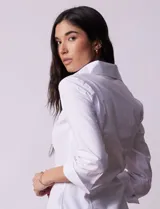 Camisa blanca de algodón marca Zac & Rachel, con cuello con solapa, abertura central con botones, delantera tableada y laterales elastizados.