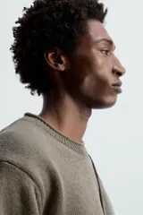 Sweater color verde oliva de punto con cuello redondo y manga larga.