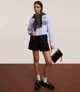 Short de sastrería color verde oliva, de corte recto y cintura alta. Presenta pliegues frontales y un detalle de medio cinturón con hebilla lateral.