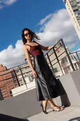 Falda midi de cuero negro, corte evasé.