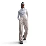 Pantalón deportivo Nike Windrunner Woven de mujer, color gris, corte holgado, cintura elastizada con cordón ajustable y bolsillos laterales.