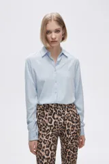 Camisa celeste de manga larga con cuello clásico y cierre frontal con botones.