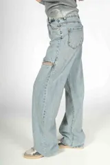 Pantalón de jean celeste de corte wide leg con roturas en las rodillas y apliques de strass.