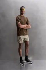 Camiseta deportiva marrón con estructura perforada, cuello redondo, manga corta y logo estampado.