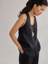 Musculosa negra de lino con escote en V y ribete color crema en cuello y sisas. Corte holgado y relajado.