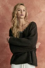 Sweater marrón de tejido de punto con escote en V y bordado blanco en el borde del escote.