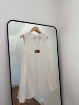 Vestido corto sin mangas confeccionado en lino de algodón, con silueta amplia y recta. Presenta bolsillos laterales y un tajo en la espalda con lazo regulable.