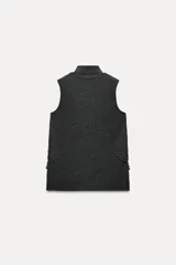 Top de punto canalé color gris oscuro, de cuello alto y sin mangas. Presenta apliques de encaje floral en los laterales del ruedo.