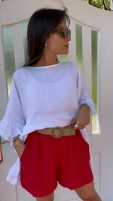 Short de lino color rojo, con cintura elástica y cinturón de rafia con hebilla circular.