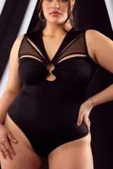 Body musculosa negro de lycra con transparencias de tul en escote y espalda, aro metálico en el centro del escote y broches en la entrepierna con refuerzo de algodón.