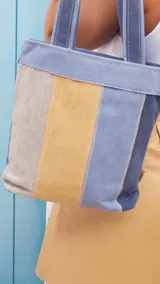 Bolsa matera de tela canvas combinada con división interna para organizar termo y mate. Incluye asa corta de mano.