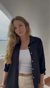 Camisa negra de crepé, de corte holgado, manga larga y cierre frontal con botones.