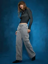 Jean cargo de tiro alto, color gris lavado, con corte ancho y pierna acampanada. Presenta bolsillos cargo grandes en los muslos y costuras marcadas.