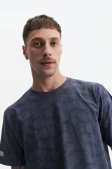 Remera blanca con estampado abstracto en tonos grises, de manga corta, corte regular y cuello redondo.