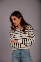 Sweater de punto color beige con rayas horizontales blancas, cuello polo con cierre de cremallera y mangas largas.