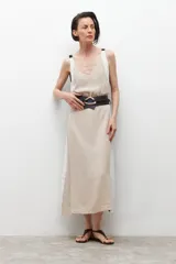 Vestido midi de lino color beige con laterales blancos, escote en V y cinturón negro con hebilla redonda.