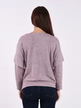 Buzo de tejido melange gris claro, con cuello en V y manga larga. El calce es holgado y el ruedo ajustado con elástico.