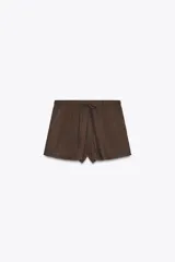 Shorts mini color marrón de tiro medio con cintura elástica ajustable con lazada y bolsillos laterales.