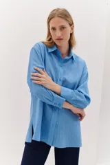 Camisa de corte oversize con textura, de manga larga y botones frontales.