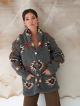 Saco de lana marrón con diseño geométrico multicolor, cuello con solapa, cierre frontal con botones y bolsillos delanteros.