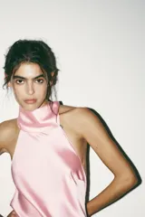 Vestido corto blanco de satén con cuello halter y espalda descubierta.