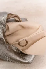 Bolso hobo reversible color azul marino, con textura símil cuero y correa bandolera extraíble.