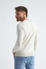 Sweater de algodón en butoné color verde, con cuello redondo, puños y dobladillo acanalados, y logo bordado en el pecho.