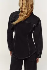 Camisa de denim color negro gastado, corte entallado, cuello solapa, manga larga, bolsillos delanteros con solapa y cierre frontal con botones dorados.