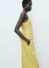 Pantalón de tiro alto, diseño recto y largo, color amarillo claro con finas rayas verticales. Presenta cierre de botón y cremallera, detalle de pinzas y dos bolsillos laterales.