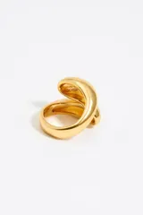 Anillo plateado de metal con diseño en espiral y logo grabado.