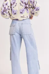 Pantalón de jean celeste de corte ancho, estilo cargo, con bolsillos laterales con solapa y detalle de costuras reforzadas.