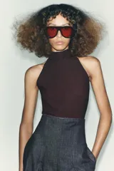 Top negro de cuello halter con cierre de botones en la parte trasera del cuello y espalda descubierta.