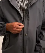 Campera gris con capucha, cuello alto, mangas largas y bolsillos con solapa y botones. Cierre frontal oculto. Marca Request, colección Primavera/Verano 2024.