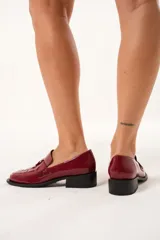 Mocasín de cuero charol color cereza con diseño enrejillado en la capellada, horma cuadrada, plataforma delantera y taco bajo.