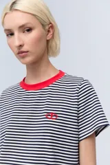Remera a rayas horizontales blancas y azul marino, de corte recto, con cuello redondo rojo y logo bordado en el pecho.