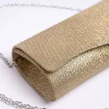 Cartera de mano tipo sobre color dorado con textura plisada y cadena metálica plateada desmontable.