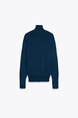 Jersey negro de punto liso con cuello alto, manga larga y detalle de botones dorados en los puños.