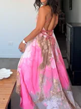 Vestido largo de tela fluida, color verde esmeralda con estampado abstracto en tonos turquesa y detalles dorados. Diseño asimétrico con un solo tirante tejido en el hombro.