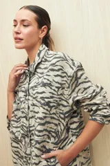 Sobrecamisa de calce amplio con estampado animal print, cuello camisero, cierre con botones, bolsillos frontales y ruedo redondeado.