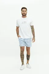 Short de baño celeste con estampado floral en blanco, cintura elástica con cordón ajustable, dos bolsillos laterales y uno trasero.