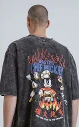 Remera negra con efecto nevado, de corte oversize y mangas cortas. Estampado frontal con diseño de Mickey Mouse vestido de chef.