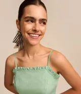 Vestido corto color verde agua, con breteles finos, escote recto con volados y falda con volado en el ruedo.
