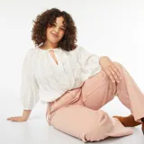 Blusa blanca con bordado calado, escote con lazo y mangas 3/4 abullonadas.